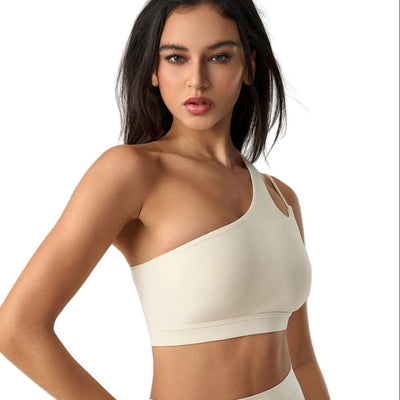 Easelyn Asymmetric One-Shoulder Sports Bra in cream, three-quarter view