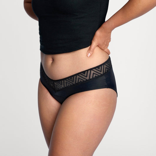 Easelyn Soft-Stretch Period Hiphugger in black, side view on model showing the V-shaped waistband