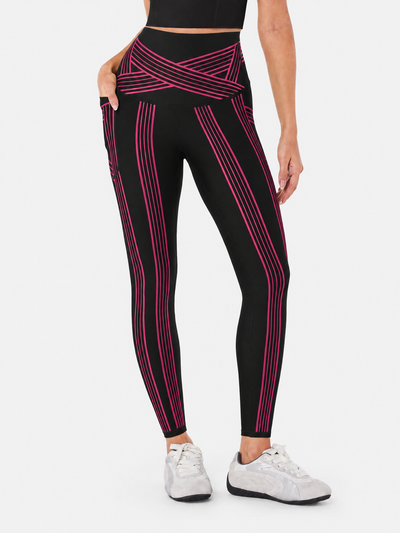 Easelyn Built-In Resistance Band Leggings in Black/Magenta, front view from the waist down showing the magenta band lines, crossover waistband and side pocket