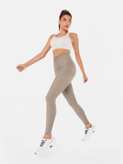 Easelyn Built-In Resistance Band Leggings in Tan, full-body view walking in stride, print side showing the tonal band lines