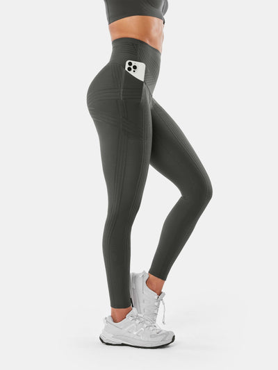 Easelyn Built-In Resistance Band Leggings in Dark Gray, side view from the waist down with a phone in the side pocket and tonal band lines