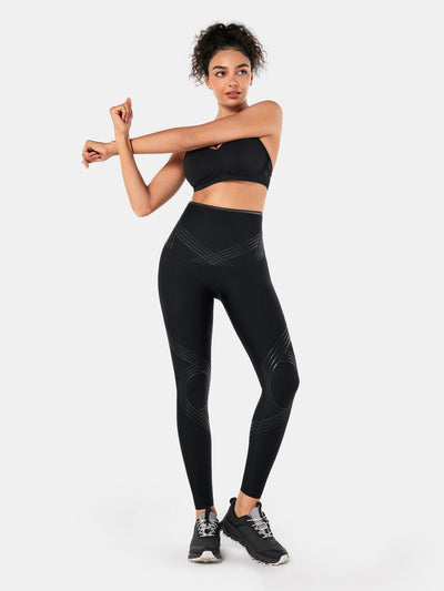 Easelyn Postpartum Recovery Compression Leggings in Black, full-body front view in a cross-body arm stretch
