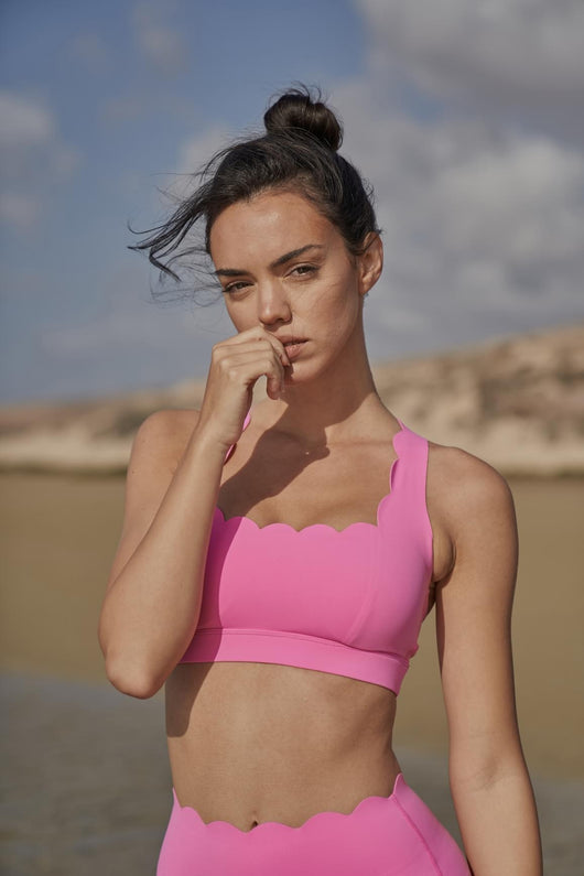 Easelyn Classic Cross-Back Sports Bra in Pink Hollywood, front close-up on the beach